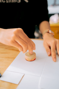 A person using a wooden stamp