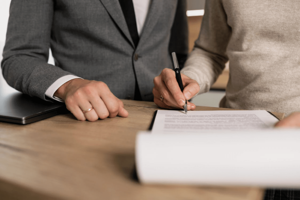 Cropped photo of a person signing a USCIS application 