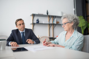 elderly woman signing documents in office