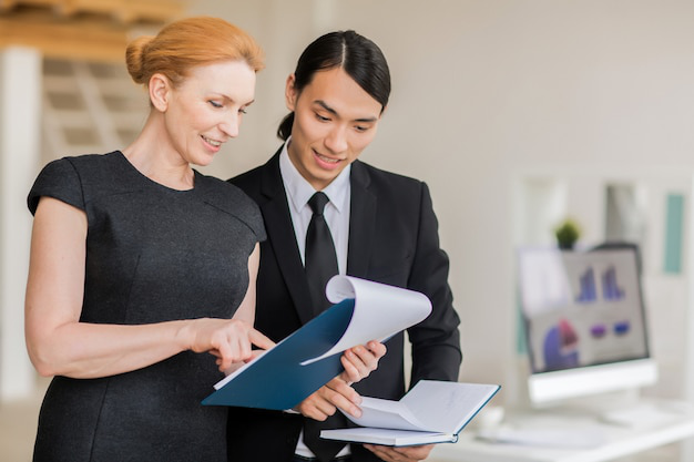  Two business professionals discussing certified translation documents in a modern office setting, ensuring quality and accuracy.