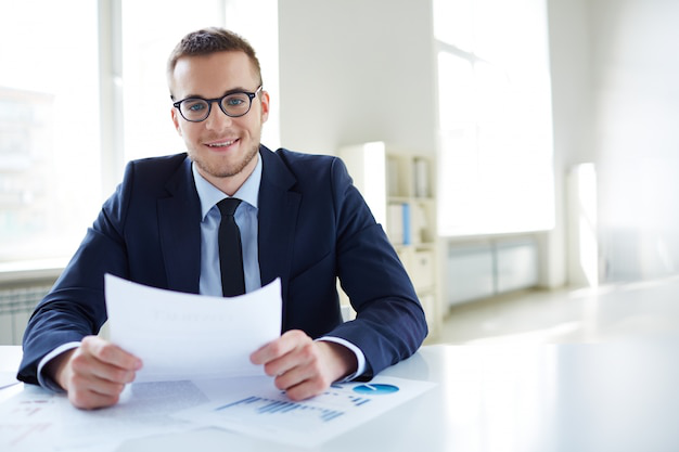Confident professional reviewing attested documents at a bright modern office desk, ready to assist with international requirements.