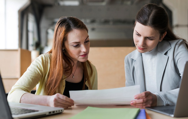 Translator with a client, reviewing university guidelines for academic document submission