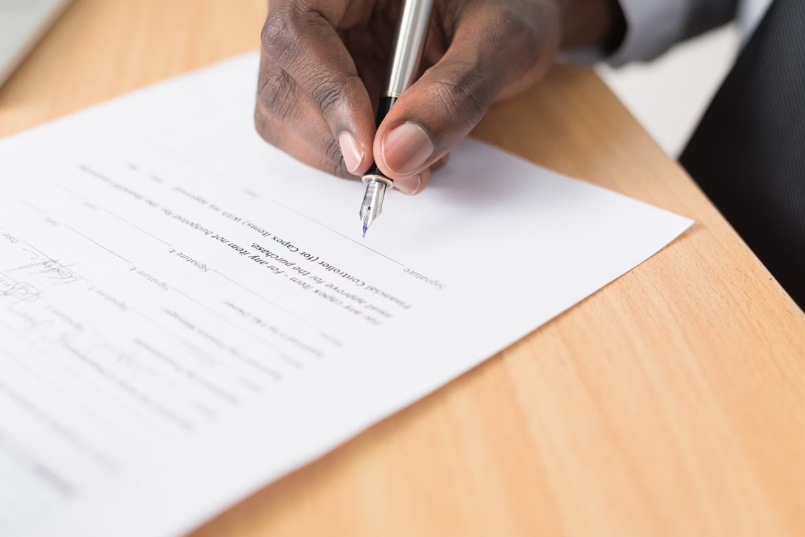 A person signs an official document.