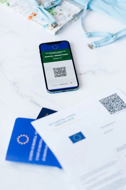Smartphone placed on top of immigration documents, including forms and identification papers.