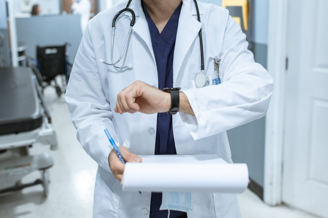 a man in a white coat holding a clipboard.