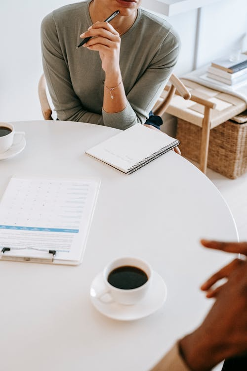 two people sitting and having a discussion over coffee.