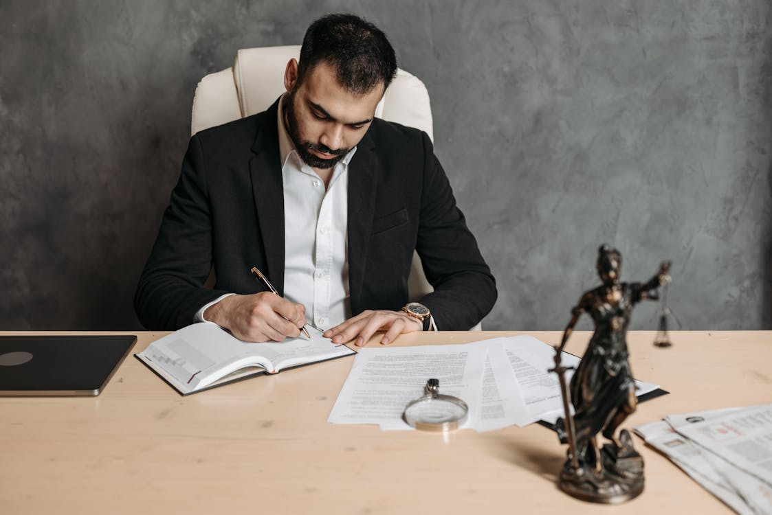a man writing in a notebook.