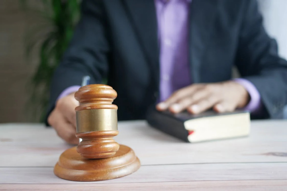 a person in a black suit holding a gavel.