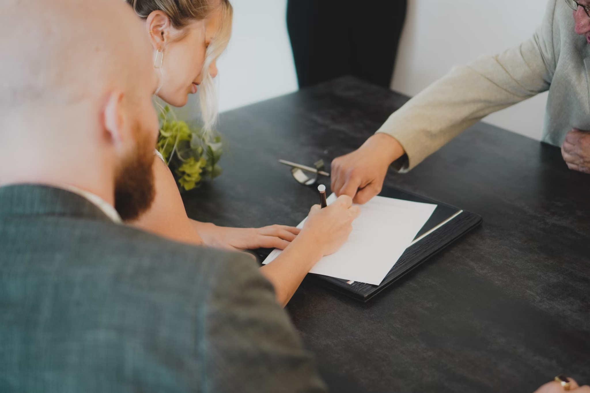 A couple signs a document in court.
