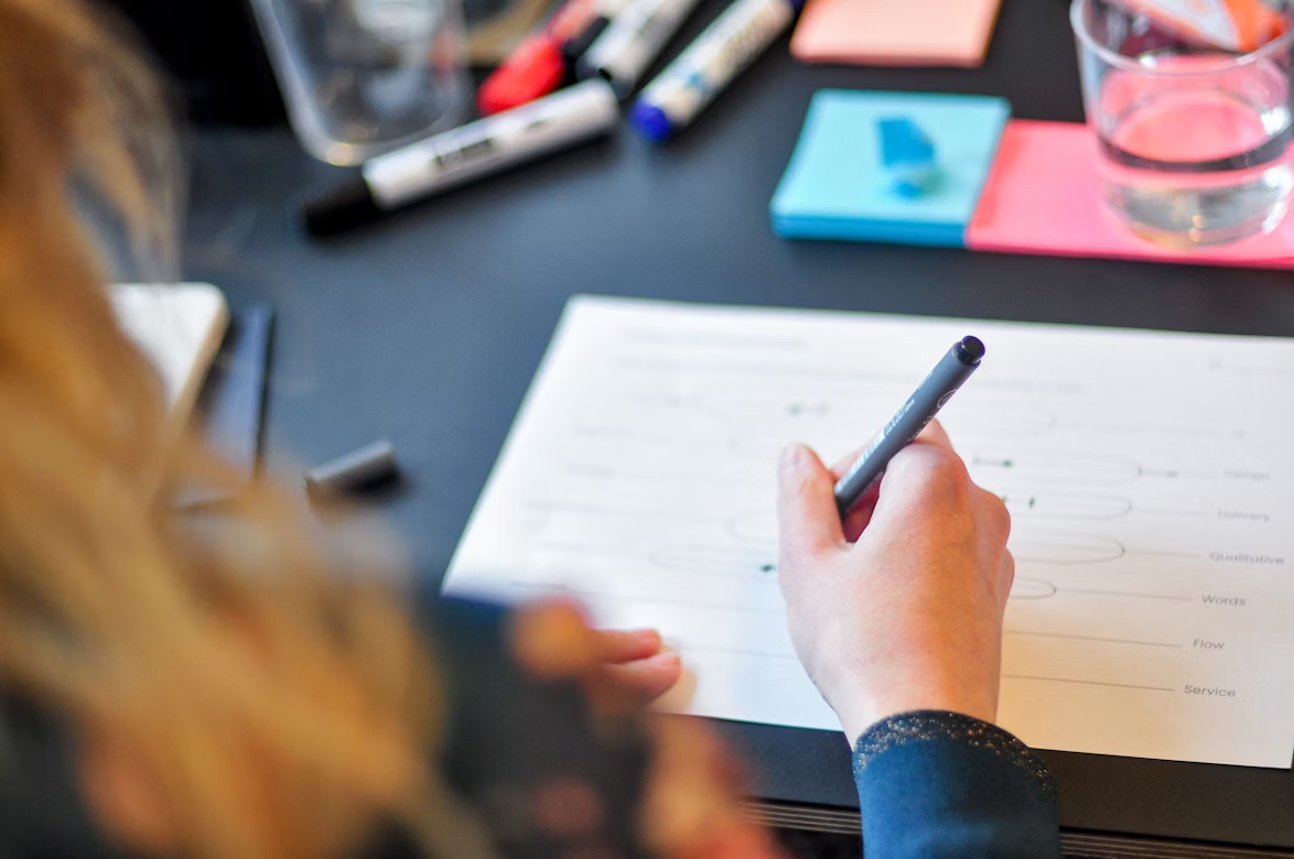  Individual writing something down on a notepad with a pen, focused on the task