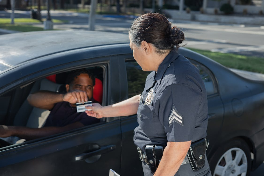 a man giving his license to a policewoman 