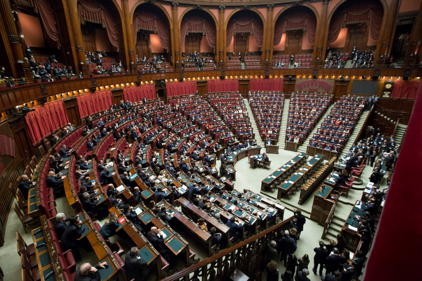 A birds-eye view of officials sitting on benches in discussion.