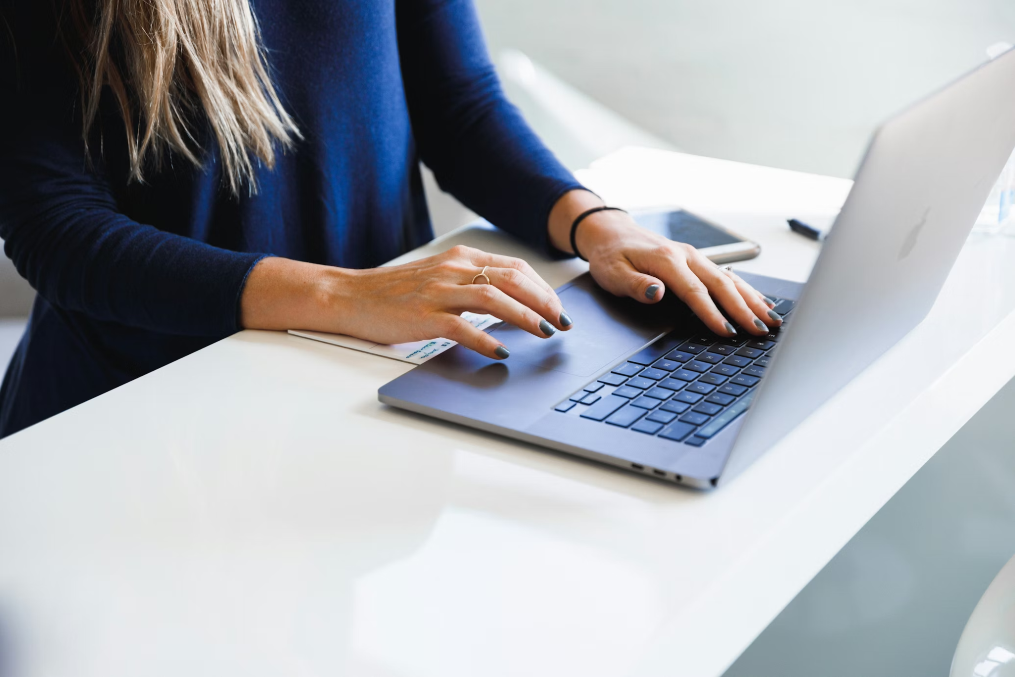 Woman working on laptop providing certified translation services for government and court acceptance