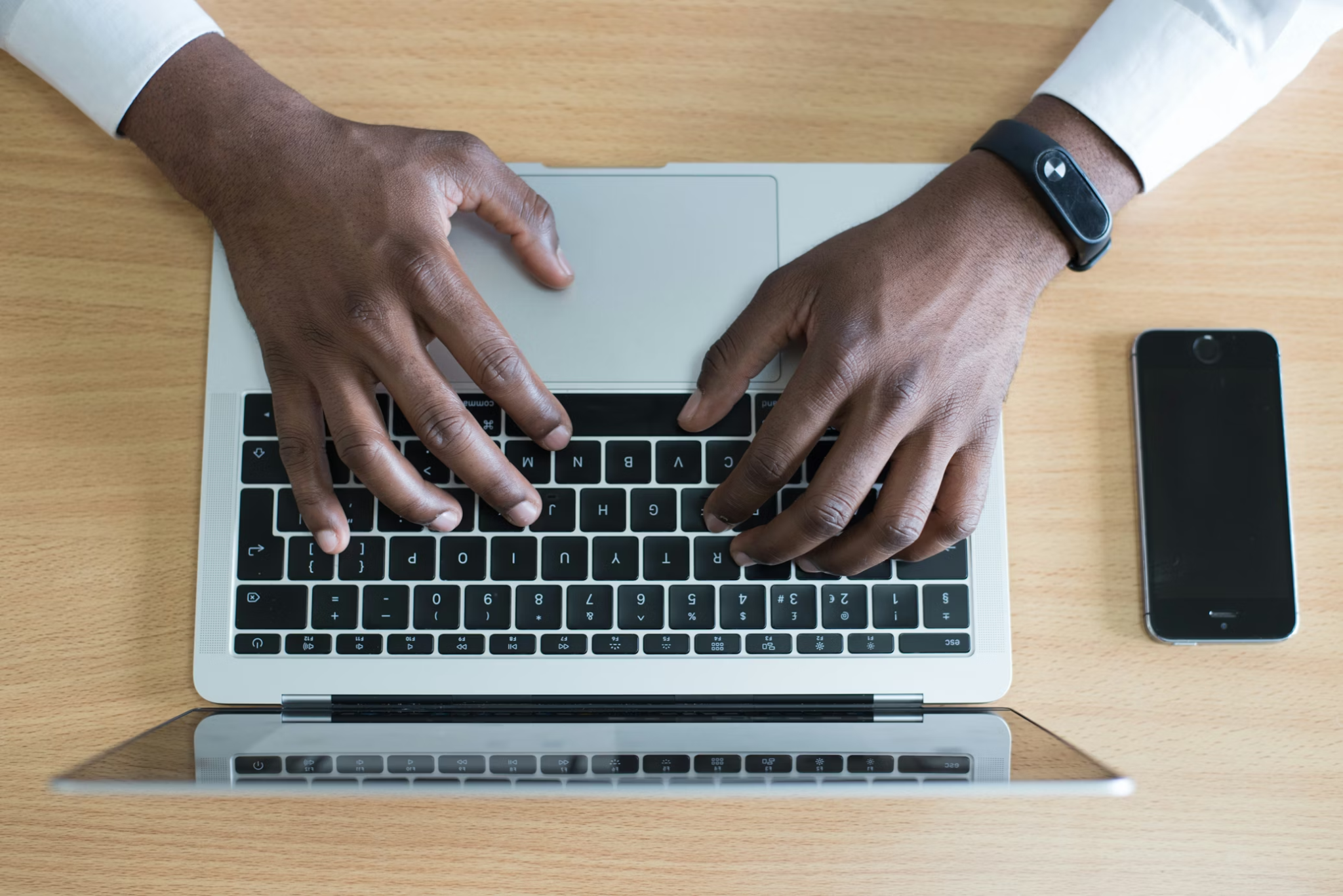 Hands typing on laptop while handling certified translation services for immigration and visa submissions