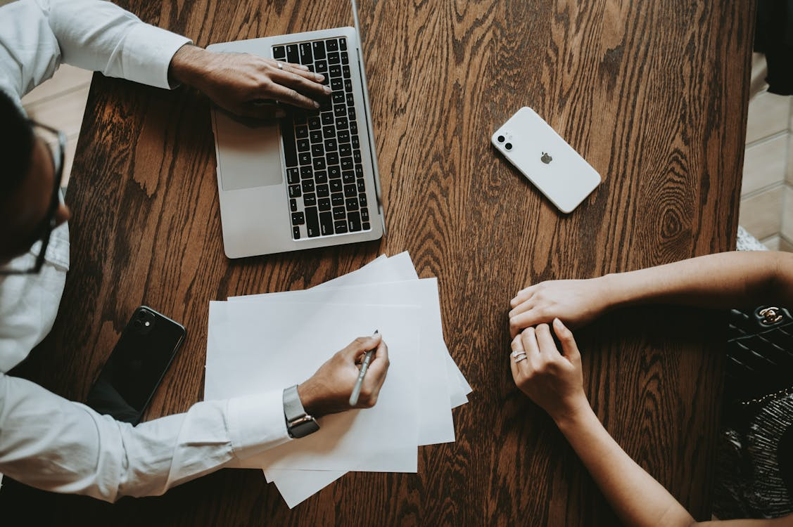 Business professionals reviewing multilingual financial documents for certified translation services and regulatory compliance