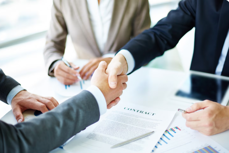 happy businessman shaking hands over translated contract documents